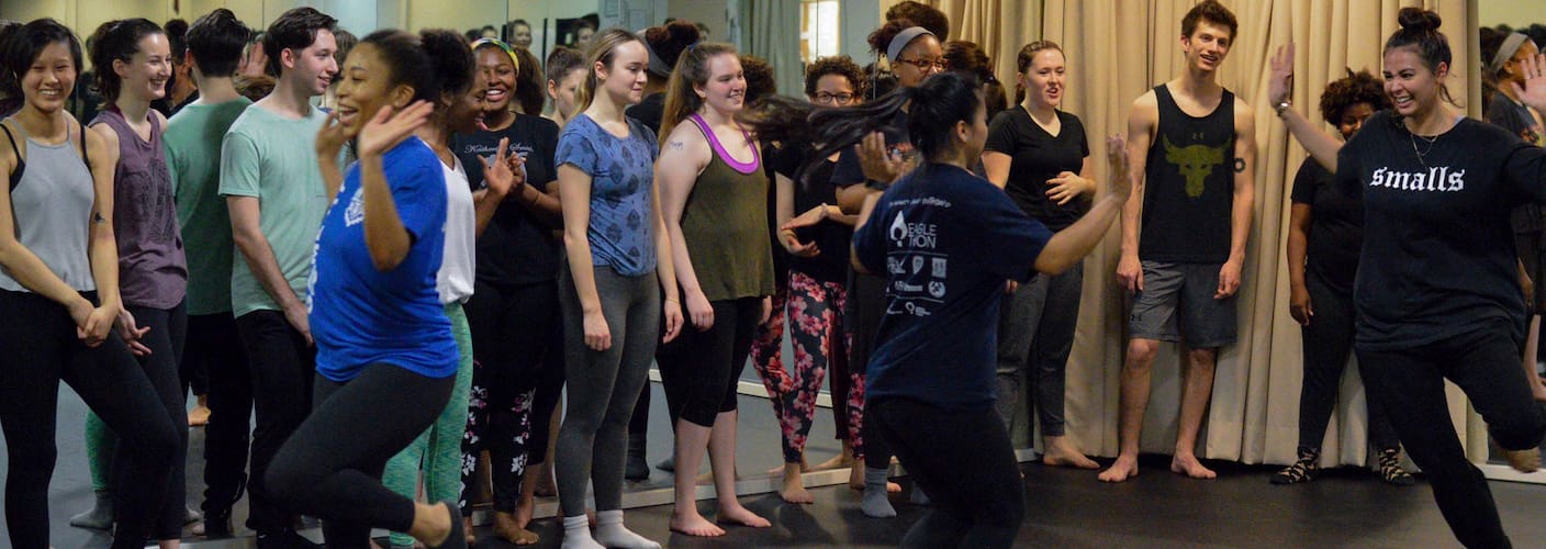 Dancers smile and dance together in a masker class