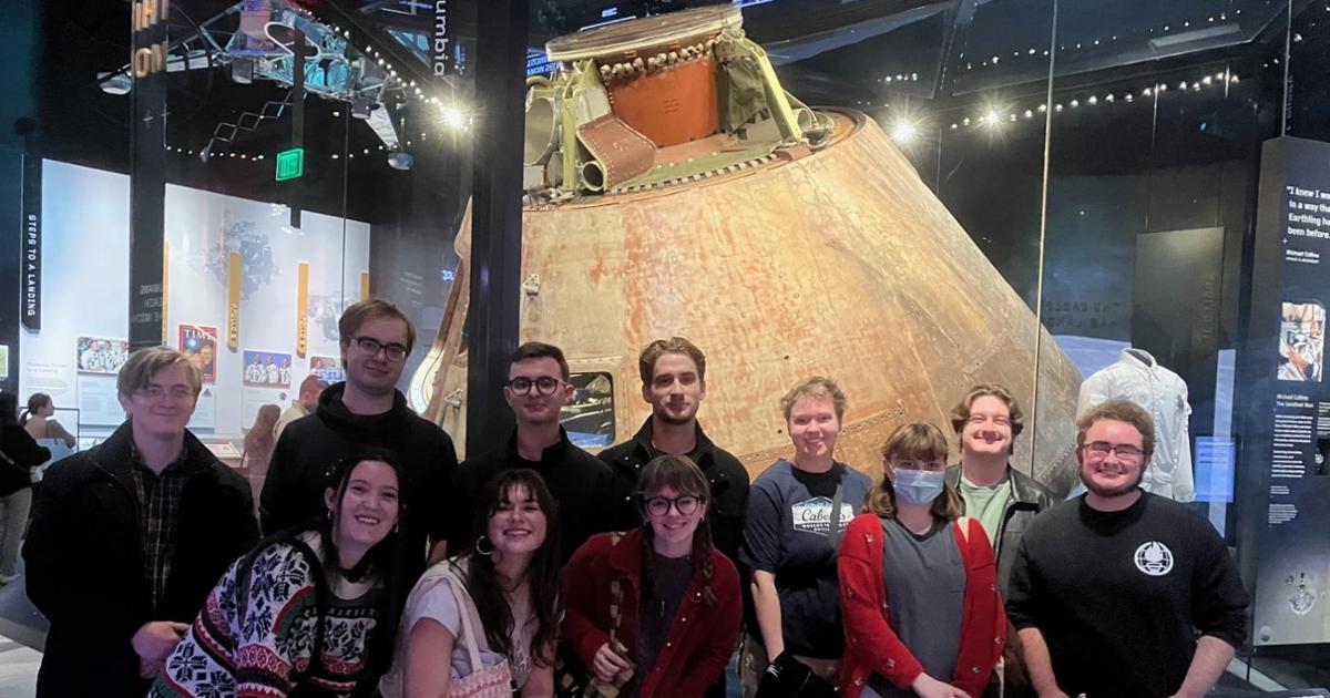 Student tour group in front of the Apollo 11 space capsule