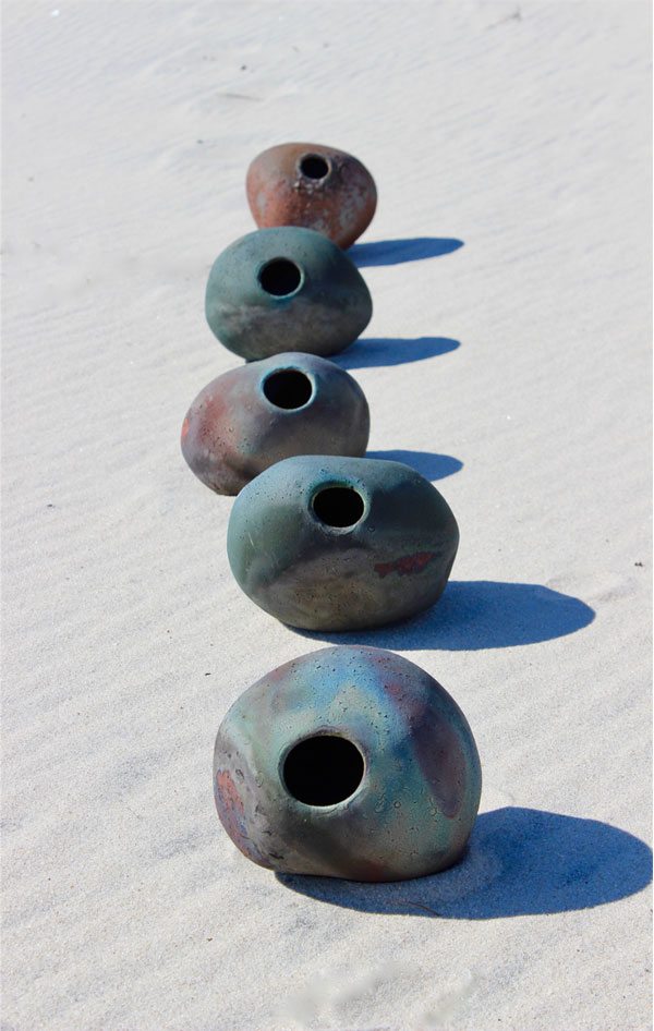 A different but similar arrangement of rock-like vessels upon sand