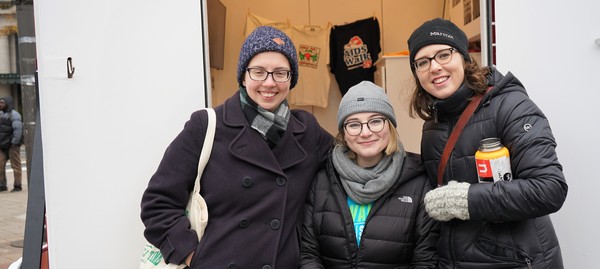 Three Public History students stand in front of the Humanities Truck