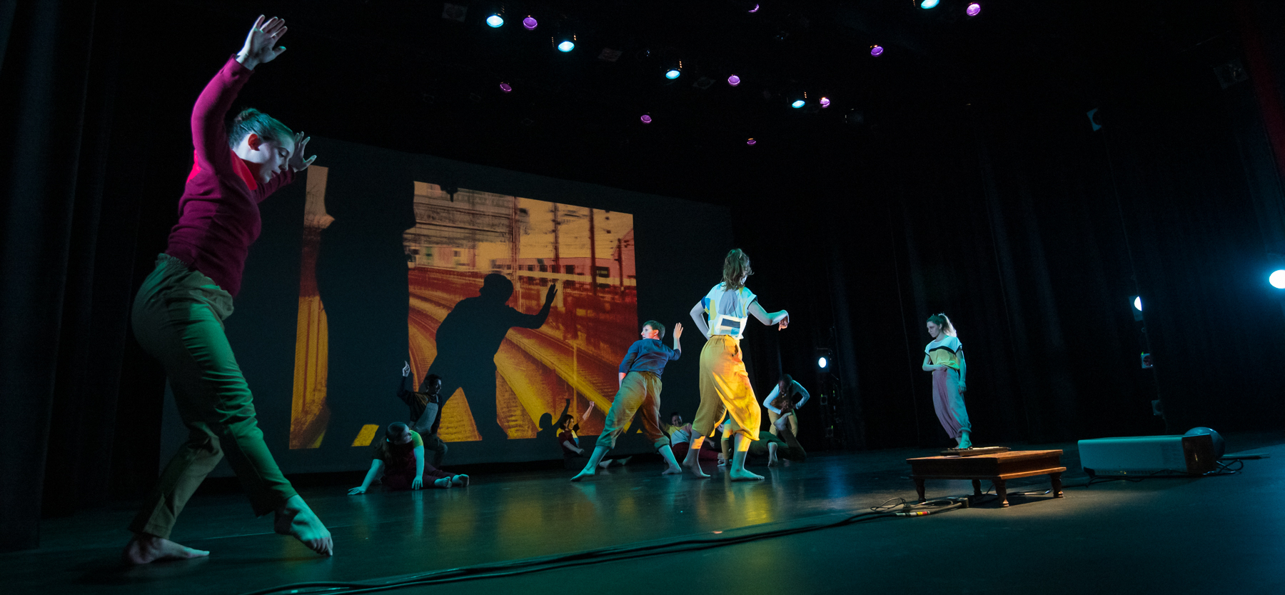 Dancers perform with projection of abstract images behind them, at the Greenberg Theatre