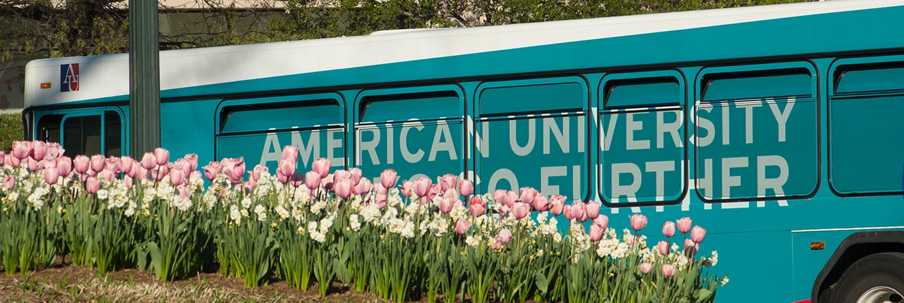 Shuttle bus on campus in spring, with tulips in foreground