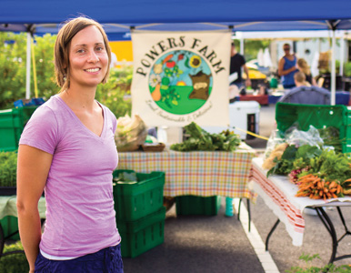 Melody Powers stands in front of her booth at a farmer's market
