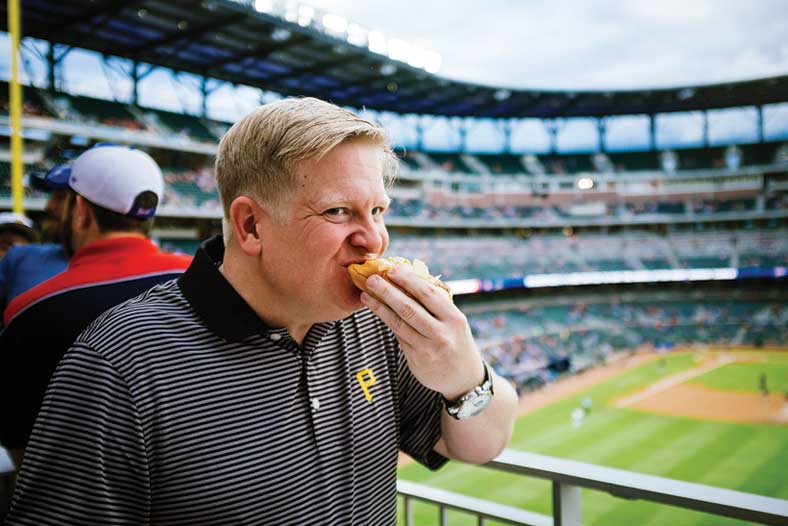 Tim Titus eats a hot dog at a ballpark in Atlanta
