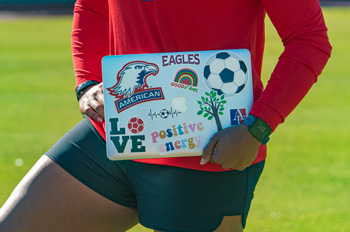 Marsha Harper holds a laptop decorated with motivational stickers
