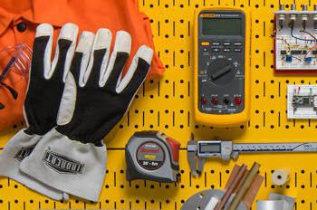 Gloves and welding apron, digital multimeter, circuit, tape measure, and calipers