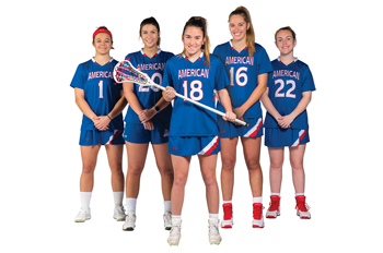 Kendall Goldblum holds a lacrosse stick and stands in front of four teammates