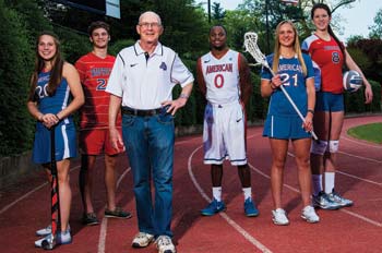 Ted Riggelheim stands in front of several AU student-athletes