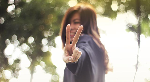 girl giving peace sign