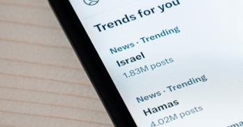 The words Hamas and Israel are shown on a smartphone screen under text that says Trends for You