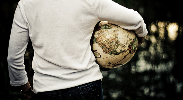 man holding a world globe on his hip