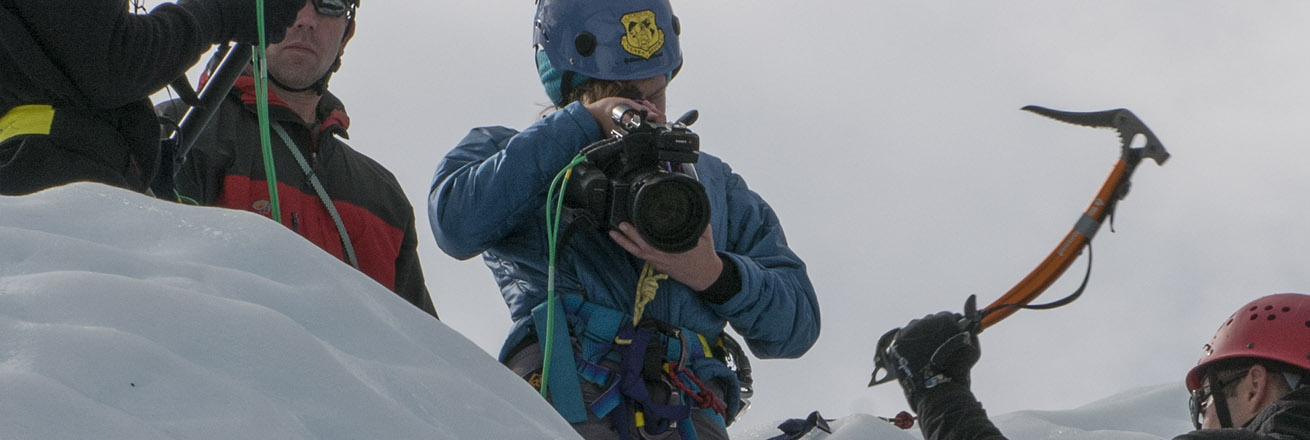 A film crew works on a glacier.