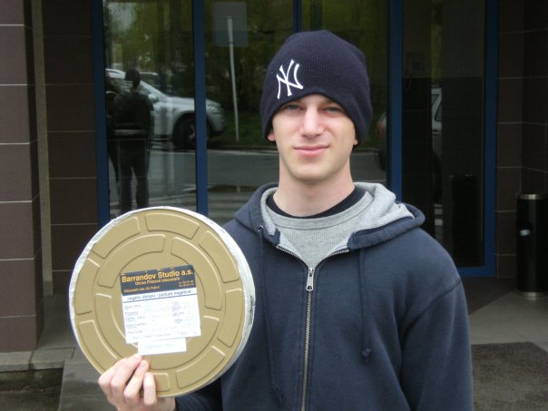 Charlie Watchel holding a film reel of his final project made during the AU Prague Aboard program.