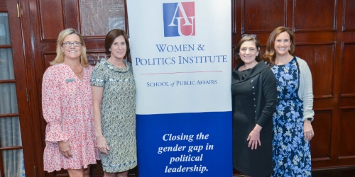 four professional women standing alongside a WeLead banner