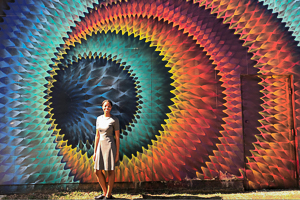 Washington Semester Program Journalism and New Media student Rachel Dennis poses in front of a giant street art piece in Washington DC