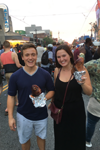 Seth and Maggie eating turkey legs at a street festival