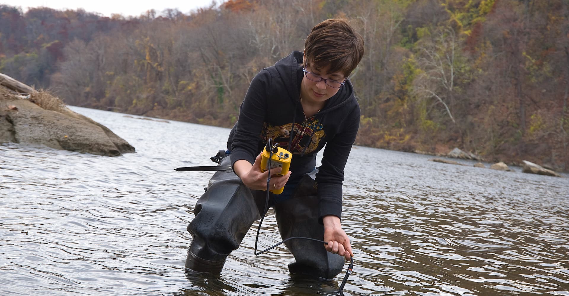 Student works on river water testing during experiential learning