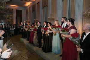 Performers stand in front of audience holding flowers at the Russian Embassy
