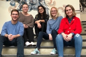 Five Design Club student officers sit on stairs.