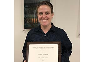 SPA Professorial Lecturer Jane Palmer holds her New Scholar Award.