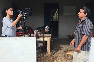 Camila DeChalus filming a Colombian farmer.