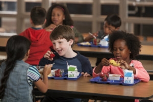School children eat healthy tray lunches.