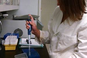 A person in a labcoat pipetting