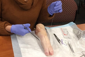Noy Kaufman learns how to suture on a pig foot.