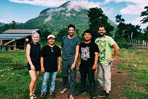 Mcgoff with production team in Laos, posing in front of a mountain
