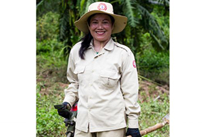  Phetsamay Sichanthavong of Lao National Unexploded Ordnance Programme (UXO Lao) standing in a field