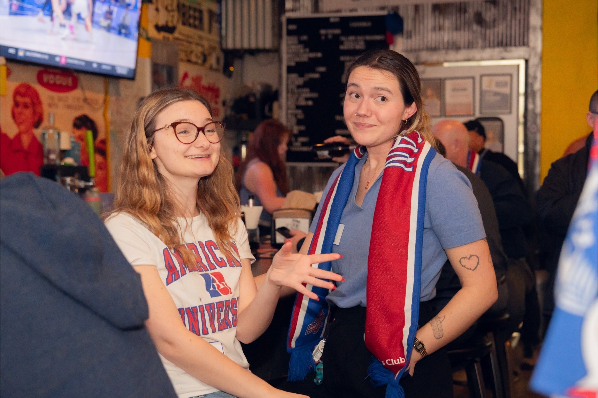 Untitled design Two young AU alumni at an Eagles watch party