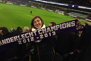 A student holds a soccer scarf up at a match