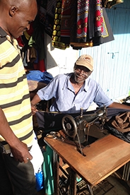 Kenyan man sewing.