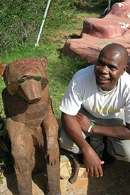 AU Nairobi program assistant standing with a statue.