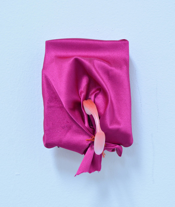 Fuscia fabric with salmon-colored phallic object on blue background