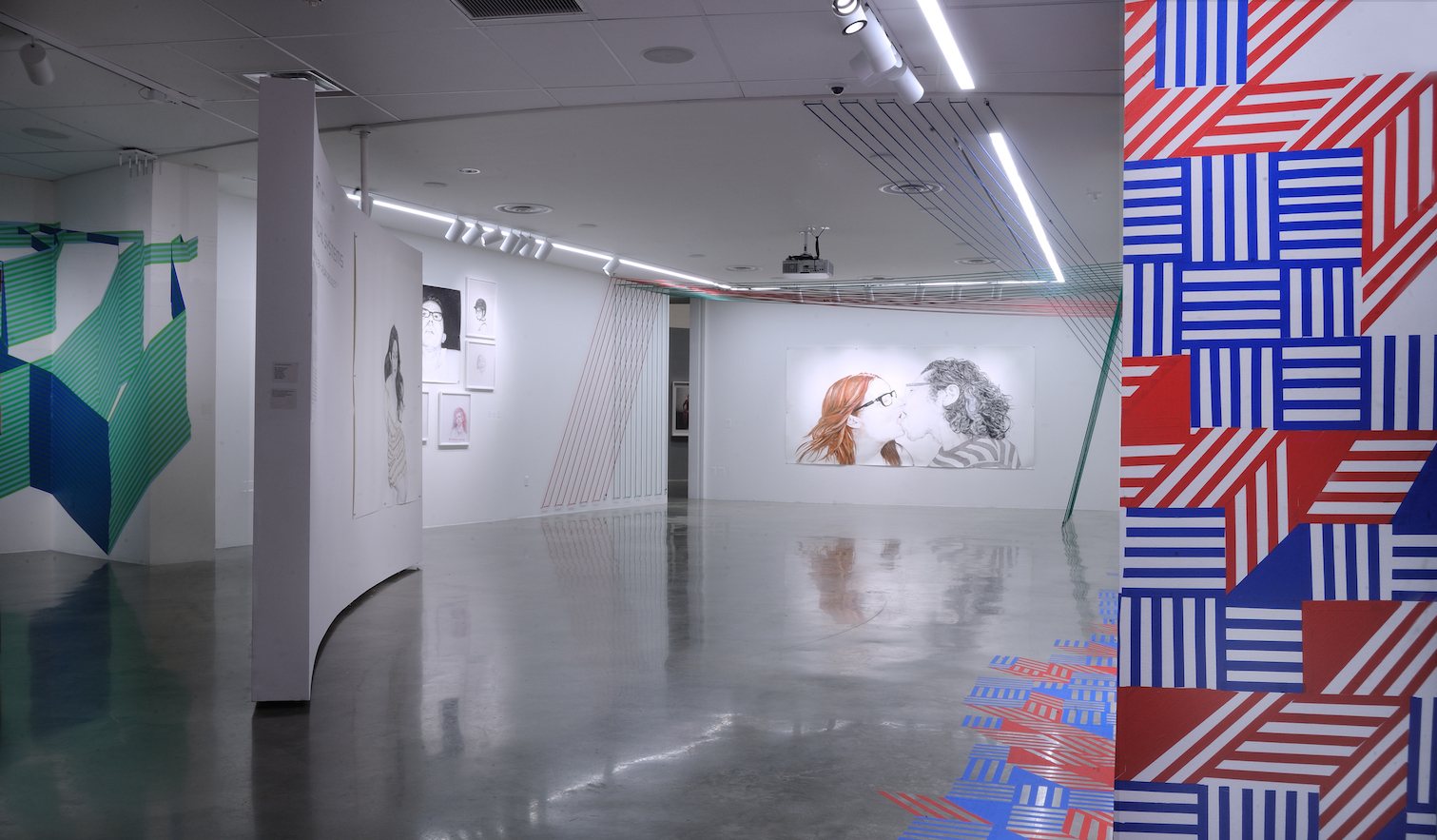 Installation view of multimedia exhibition with portraiture and bungee cords