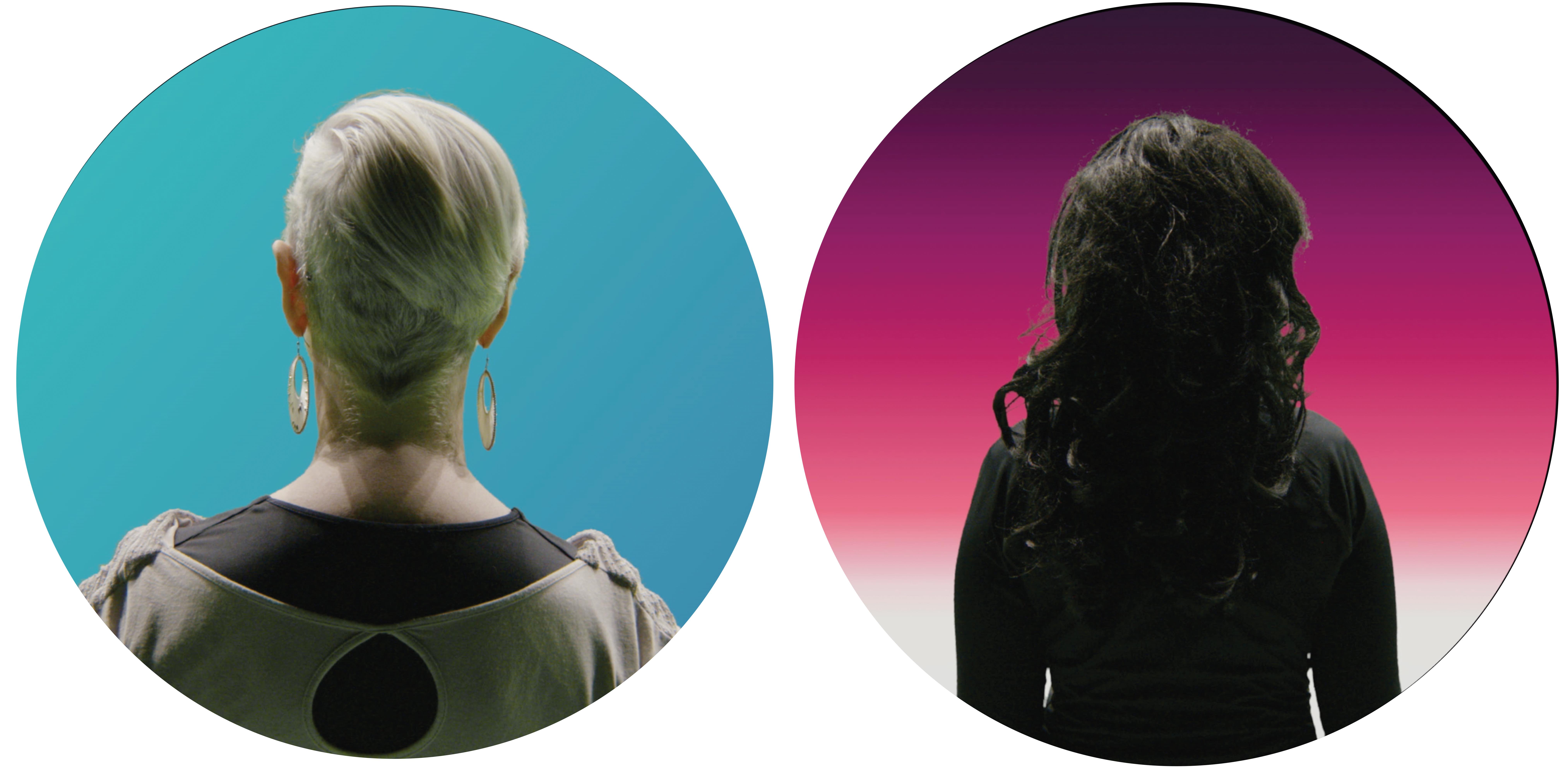 Two women from behind, one with short blonde hair and one with long brunette hair