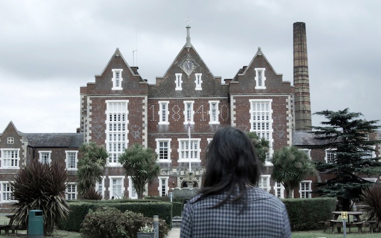 A young woman standing in front of a hospital