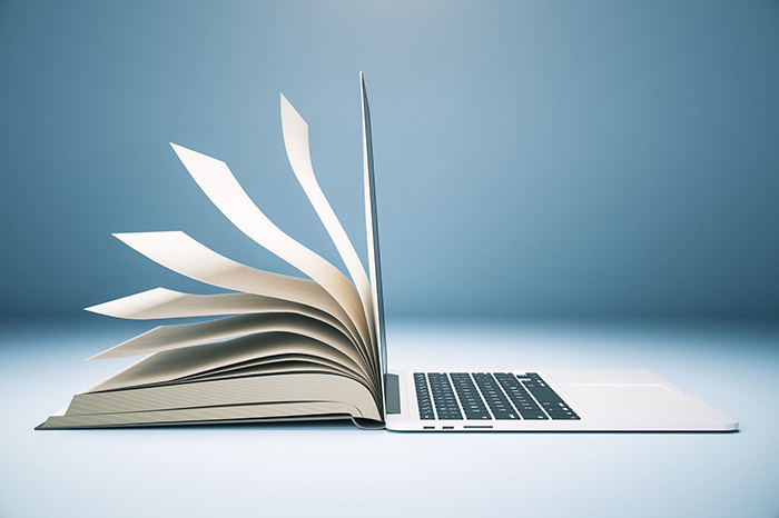 A book flipping into a laptop
