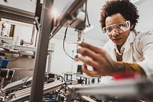 A woman in a lab coat uses equipment in the lab