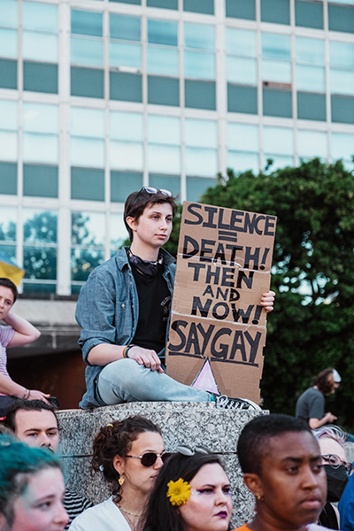 A person at Pride holding a protest sign