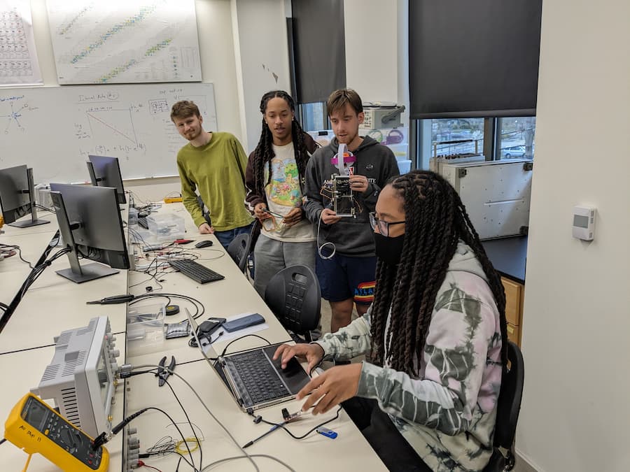 Students (left to right) Caleb Dando-Haenisch, Zaki Hawkins, Eli Rockenbeck, and Ihsan Hawkins developing software on the payload. 