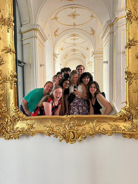 AU Chambers singers take a selfie via an ornamental mirror