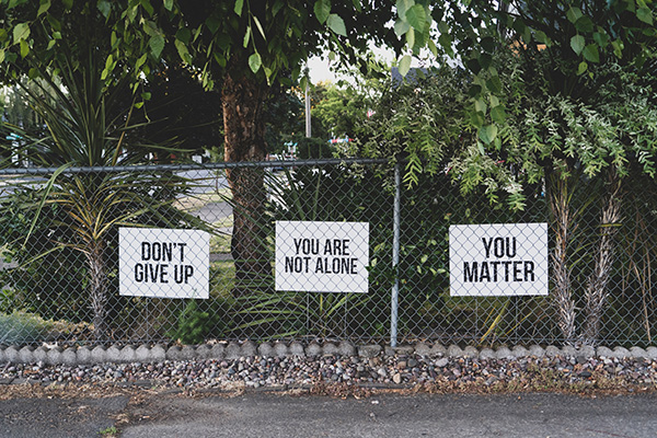 Signs on a fence with positive affirmations