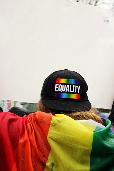 A person wearing a rainbow equality hat