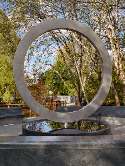 open metal circle sculpture among trees