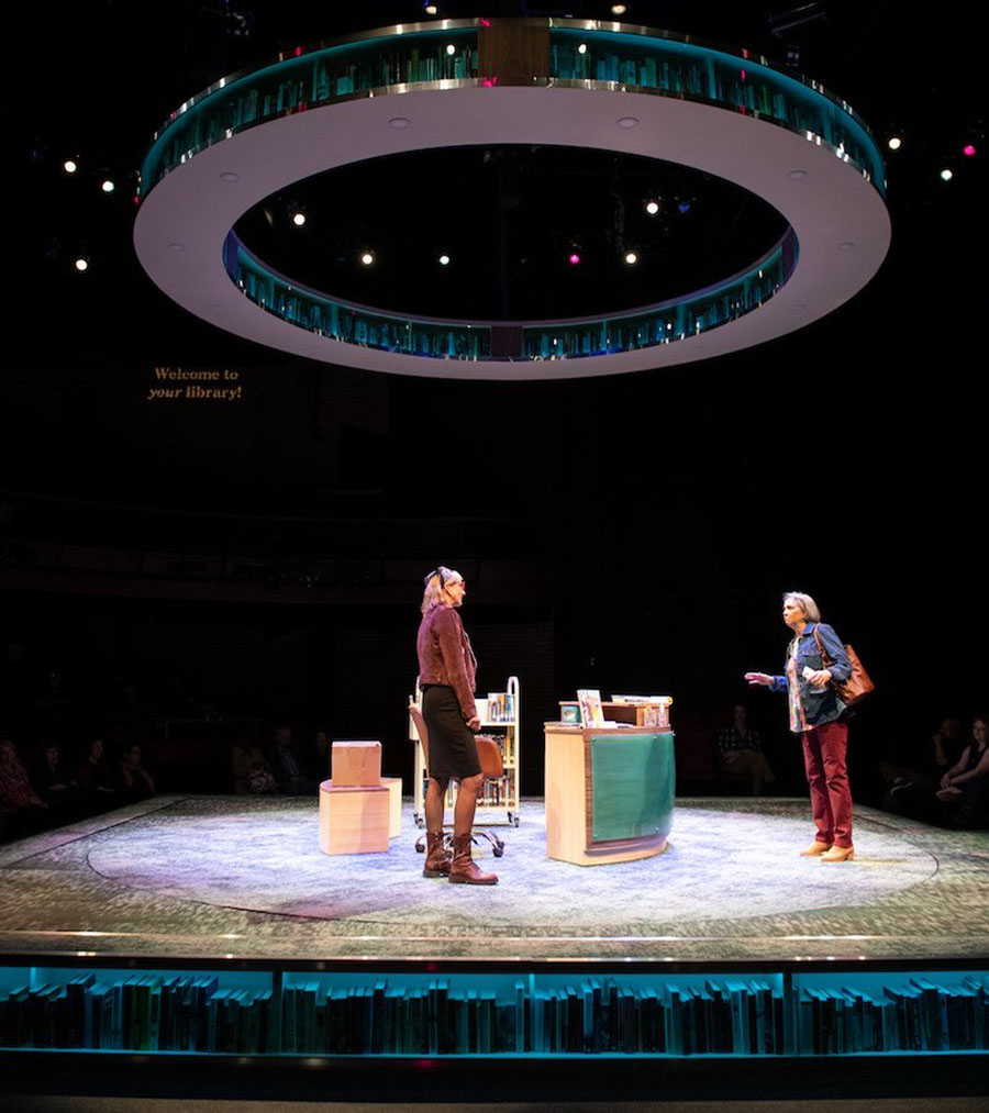 Bookshelf circle above stage with round librarian desk.