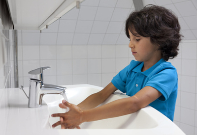 Child washes hands at sink