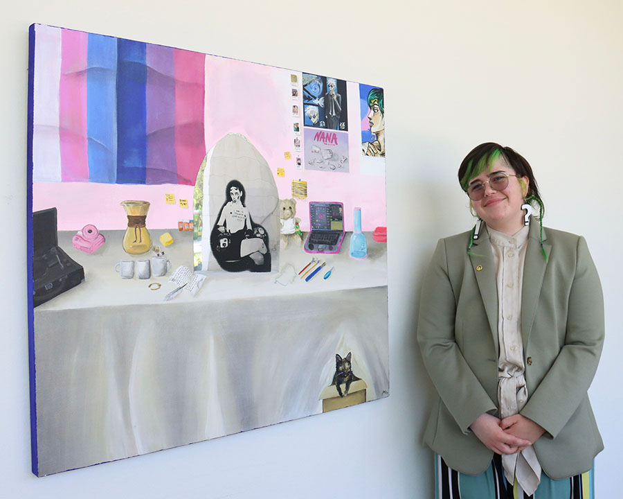 Jamison Rohan with artwork: painting of tabletop arranged with various objects
