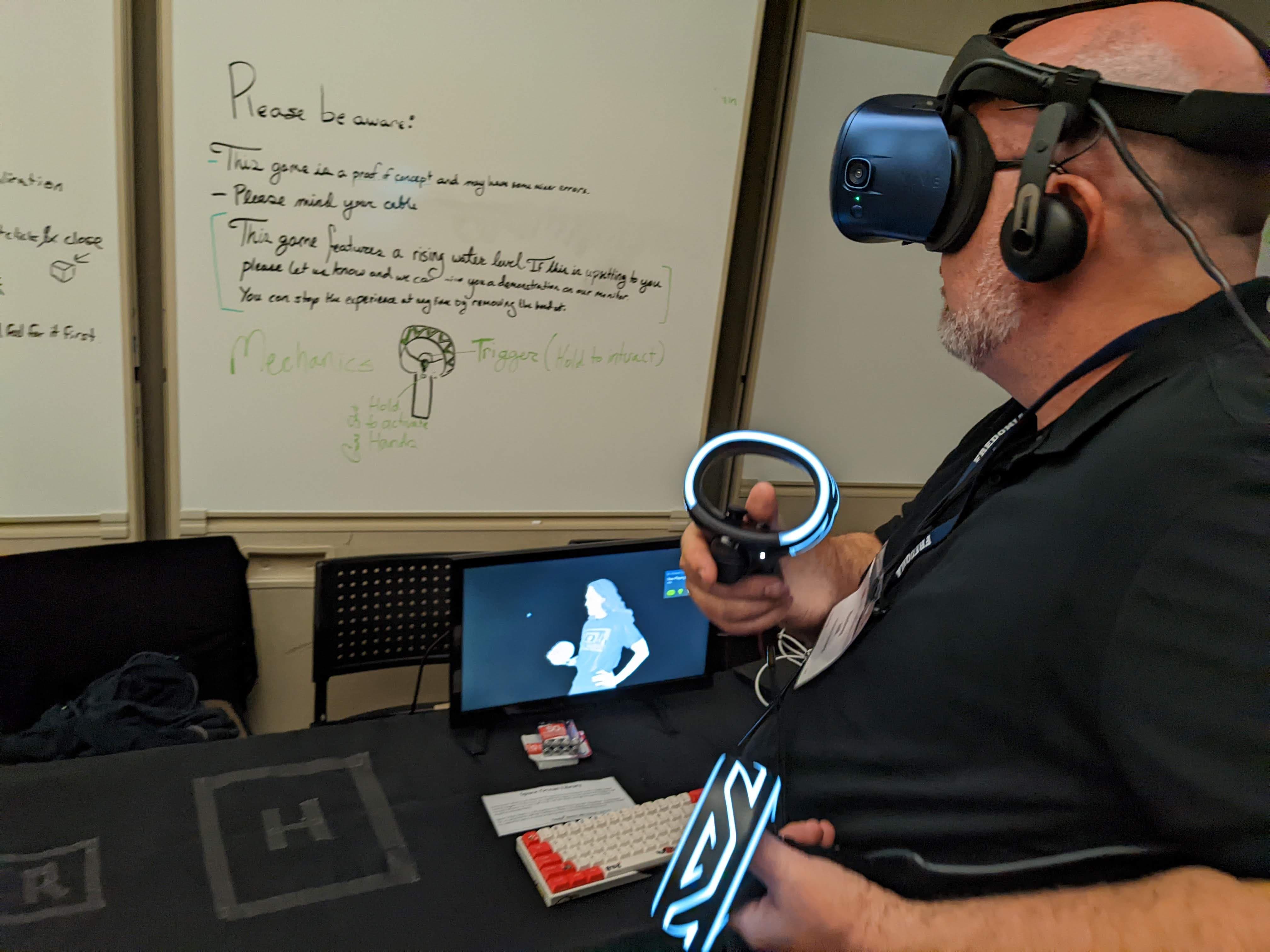A person interacts with a VR experience while wearing a headset and operating a set of controllers